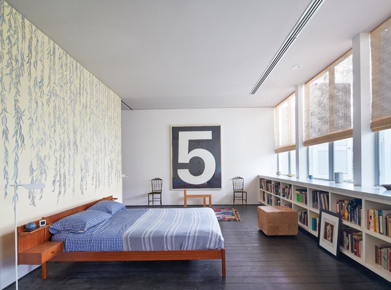Bedroom with bookshelves and artwork