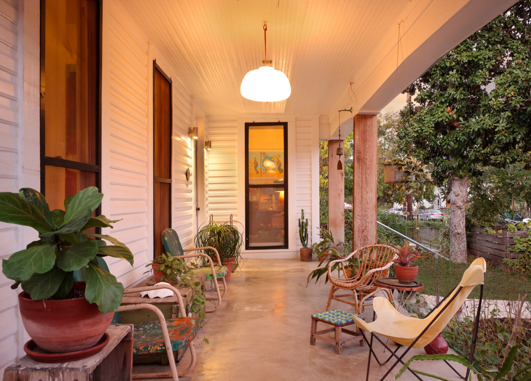 Covered porch with plants and wicker chairs
